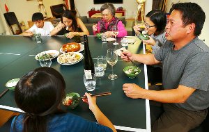 Charles Phan at home eating with his family.