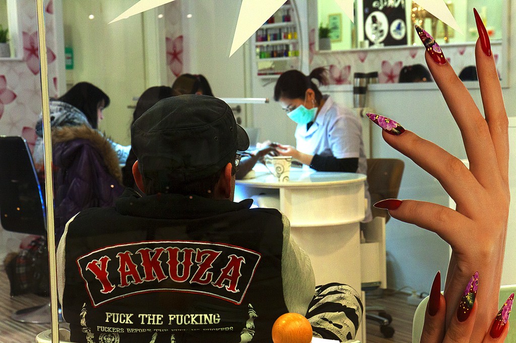 Man wearing a YAKUZA jacket inside Vietnamese nail salon, Leipzig.