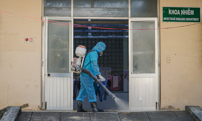Medical staff disinfecting hospital entrance
