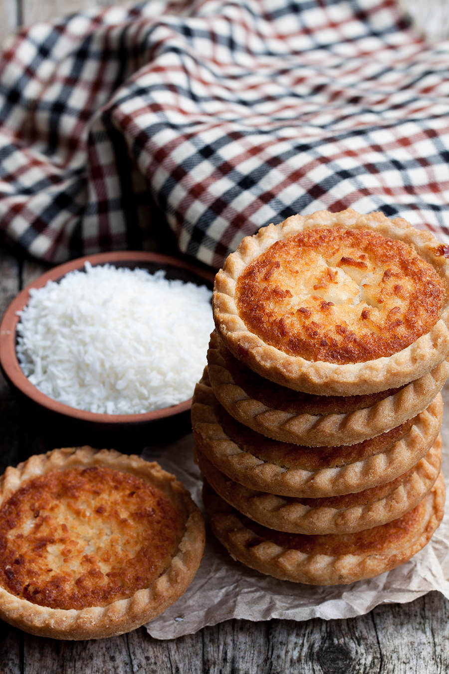 Stack of coconut tarts on wooden table