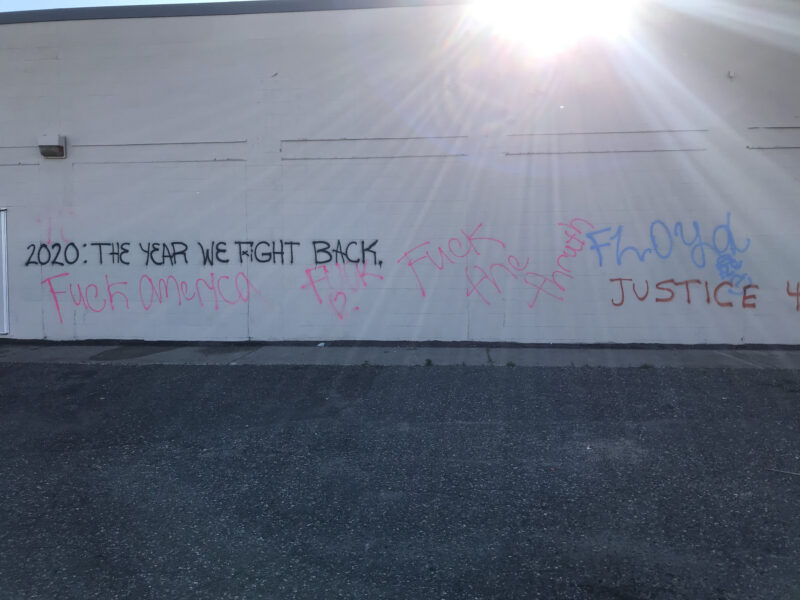 Graffiti on the side of a white building that reads "2020: The Year We Fight Back," "Fuck America," "Fuck [heart emjoi]," "Fuck the thruth," "Floyd," and "Justice"